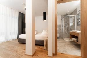 ein Schlafzimmer mit einem Bett und einer Dusche sowie ein Badezimmer in der Unterkunft Philipp by A CASA in Sölden