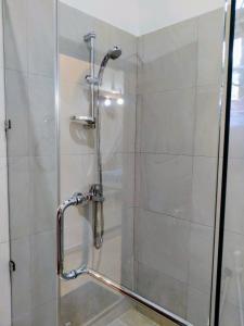 a shower stall with a glass shower door at Siroma Villa in Bentota