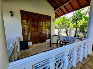 a balcony of a house with a table and chairs at Siroma Villa in Bentota