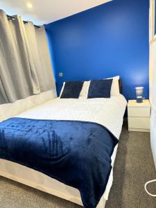 a blue bedroom with a bed with a blue wall at Flat 507 Modern Luxury Living in Yeadon