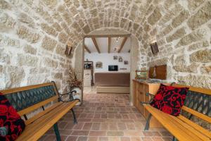 2 bancs dans une pièce avec un mur en pierre dans l'établissement Apartment in Porec - Istrien 46934, à Poreč