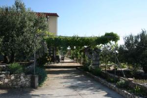 プリモシュテンにあるHoliday home in Primosten - Sibenik Riviera 43222のブドウの木のアーチのある庭園