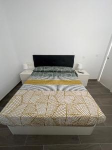 a large bed in a room with two night stands at Apartamentos Montalvo Metropolis C in Torremolinos