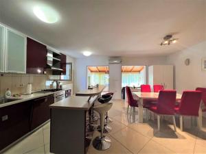een keuken en eetkamer met een tafel en rode stoelen bij Apartments in Medulin - Istrien 46722 in Medulin