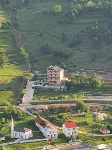 una vista aérea de una casa en una colina con una iglesia en LURA Hotel, en Peshkopi