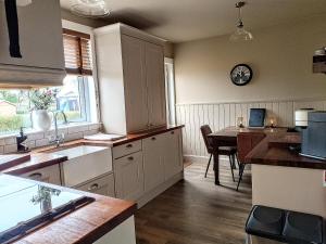 a kitchen with a table and a clock on the wall at Auld Tom's Rest in St. Andrews