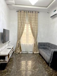 a living room with a couch and a television at Urban Haven in Lekki