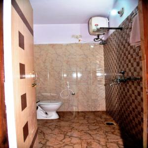 a bathroom with a toilet and a shower at GRG Royal Surya Inn Gaya in Gaya
