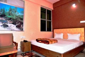 a bedroom with a bed and a window at GRG Royal Surya Inn Gaya in Gaya