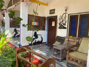 a porch of a house with a table and chairs at Star Rest Beach Hotel in Arugam Bay