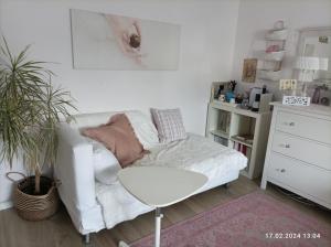 sala de estar con sofá blanco y mesa en Romantischer Traum, Zimmer mit TV inkl Netflix und Prime, super late check in möglich en Bielefeld