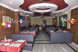 a dining room with red tables and balloons on the ceiling at GRG Royal Surya Inn Gaya in Gaya
