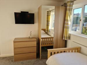 a small bedroom with a crib and a mirror at Minster Leas in Sheerness