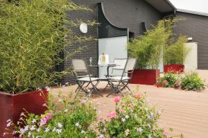 d'une terrasse avec des chaises, une table et des fleurs. dans l'établissement Logis Hostellerie Du Mont Aimé, à Bergères-lès-Vertus