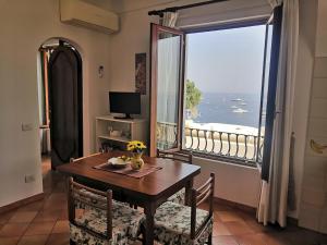 a dining room with a table and a large window at Sorrento Holidays - Casa Marcella in Positano