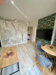 Una sala de estar con televisión, mesa y sillas. en Maison ville T2 quartier calme Parking Gratuit, en Saint-Julien-les-Villas