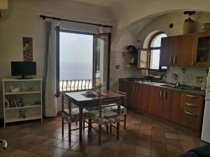 a kitchen with a table and a view of the ocean at Sorrento Holidays - Casa Marcella in Positano +23 photos