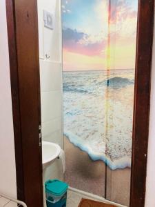 a bathroom with a shower with a view of the ocean at Sacavem Flat Hotel Navegantes in Navegantes