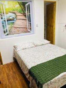 a bed in a room with a painting on the wall at Sacavem Flat Hotel Navegantes in Navegantes
