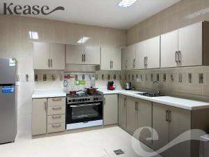a kitchen with white cabinets and a stove top oven at Kease Al-Mutamarat A-10 Timeless History GX66 in Riyadh