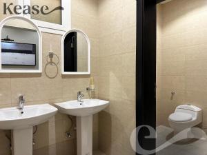 a bathroom with two sinks and a toilet at Kease Al-Mutamarat A-10 Timeless History GX66 in Riyadh