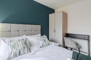 1 dormitorio con cama blanca y pared azul en Quiet 3 Bed House, Free EV Parking, York City en York