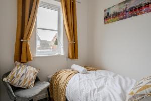 a bedroom with a bed and a window and a chair at Quiet 3 Bed House, Free EV Parking, York City in York