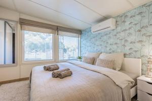 een slaapkamer met een groot bed en 2 handdoeken bij Očarujúci Houseboat na Dunaji in Bratislava