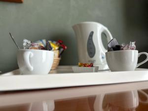 due tazze di caffè sedute su un tavolo con piano di lavoro di Logis Hostellerie Du Mont Aimé a Bergères-lès-Vertus