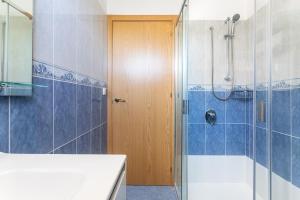 a bathroom with a shower and a wooden door at Apartamentos Mirador in Benidorm +88 photos