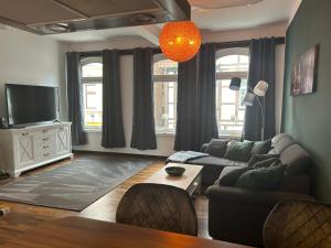 een woonkamer met een bank en een tv bij Stangenberg`s City Loft in Hameln
