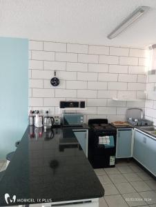 - une cuisine avec un comptoir noir et une cuisinière dans l'établissement Sea Breeze, à Margate