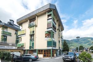 ein Gebäude mit davor geparkten Autos in der Unterkunft TUCA - Apartamento en Vielha in Vielha e Mijaran