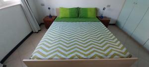- un lit avec 2 oreillers verts dans l'établissement Top Residence Beach, à Santa Maria