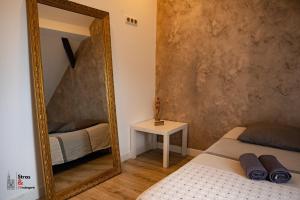 een spiegel in een kamer met een bed en een tafel bij Belles combles alsaciennes au centre de Strasbourg in Straatsburg