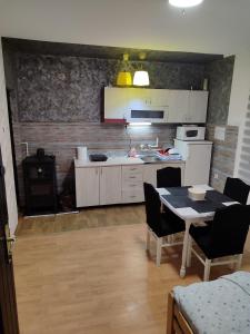 uma cozinha com uma mesa, cadeiras e um fogão em Kuršumlijska banja apartman em Kuršumlija