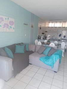 - un salon avec un canapé gris et des oreillers bleus dans l'établissement Sea Breeze, à Margate