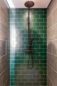 a green tiled shower with a shower head at Pierview Pad - Central Luxury Apartment on the Beach in Brighton & Hove