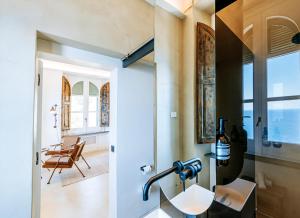 een badkamer met een wastafel en uitzicht op een kamer bij Faro Punta Imperatore in Ischia