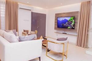 ein Wohnzimmer mit einem Sofa und einem TV in der Unterkunft Harmony villa in Tema