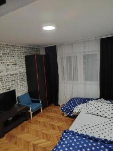 um quarto com 2 camas, uma secretária e uma cadeira em Kuršumlijska banja apartman em Kuršumlija