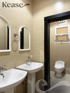 a bathroom with two sinks and a toilet at Kease Al-Mutamarat A-8 Timeless History GZ29 in Riyadh