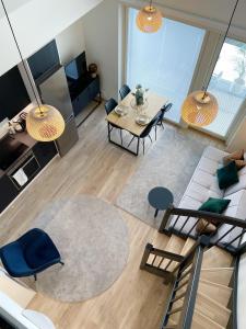 a living room with a couch and a table at Bright loft apartment with glazed balcony in Tampere