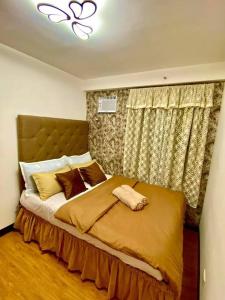 ein Schlafzimmer mit einem großen Bett mit gelber Bettwäsche und Kissen in der Unterkunft Cozy Condo with Swimming Pool, WIFI & Netflix good for 4PAX in Davao City