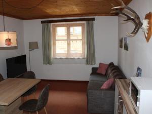 ein Wohnzimmer mit einem Sofa und einem Tisch in der Unterkunft Apartment with mountain view near centre in Maria Alm am Steinernen Meer