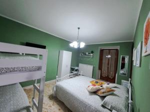 RoccamandolfiにあるB&B Vivilmateseの緑の壁のベッドルーム1室(二段ベッド2組付)
