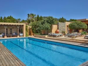 a swimming pool in a yard with a house at Cozy three bedroom villa with Es Vedra views! in Cala Vadella