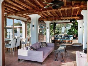 een woonkamer met een bank en een tafel bij Beautiful villa for 12 people in San Jose de sa Talaia