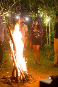 um grupo de pessoas andando em torno de uma fogueira em Green Wild Yala - Luxury Camping & Free Safari Tour em Yala