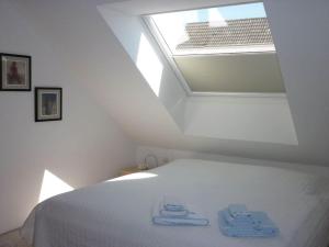 - une chambre avec un lit blanc et une lucarne dans l'établissement Holiday apartment near beach, à Steinhude